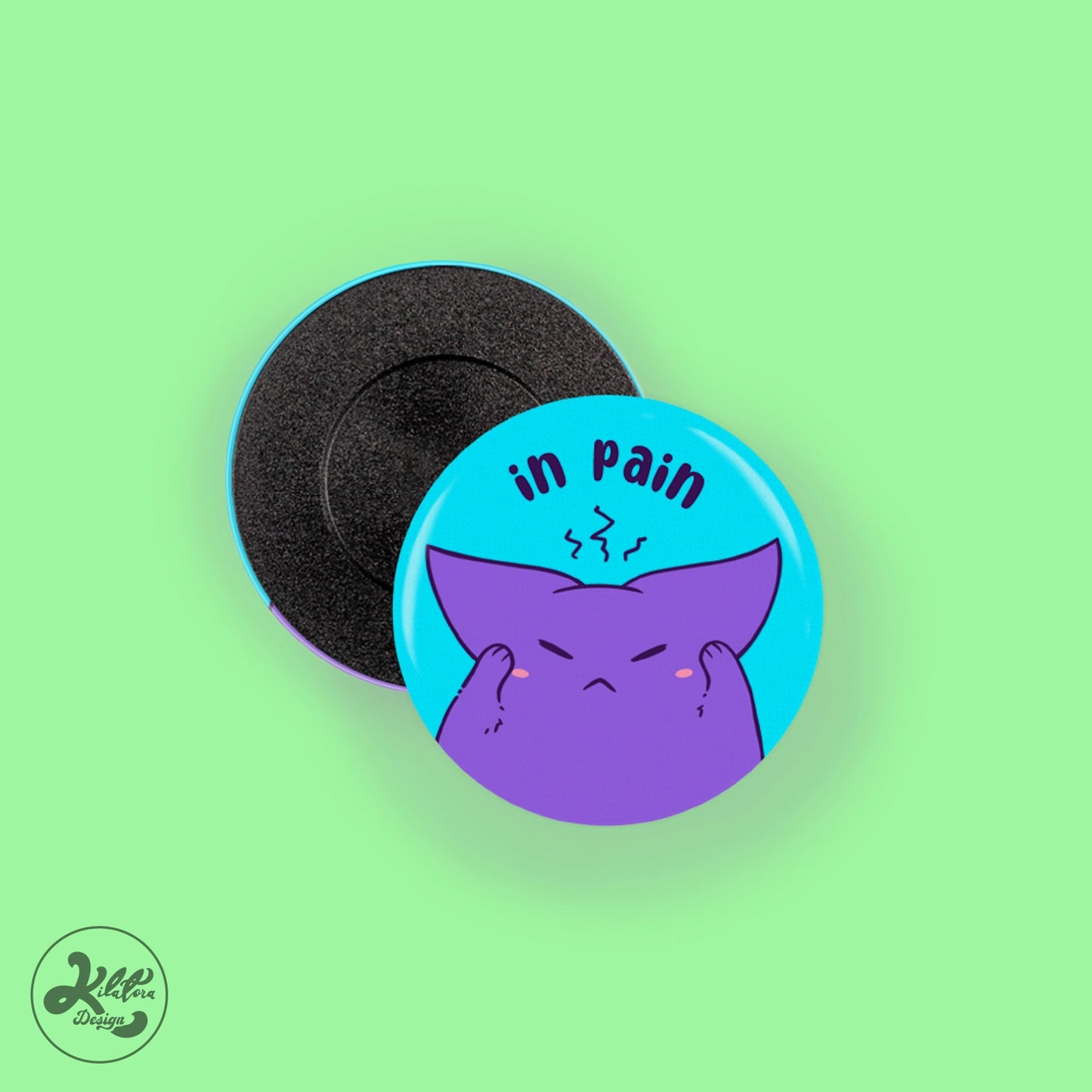 38mm magnet by Kilatora Design. Blue pin with Tora holding his head and the text "in pain".