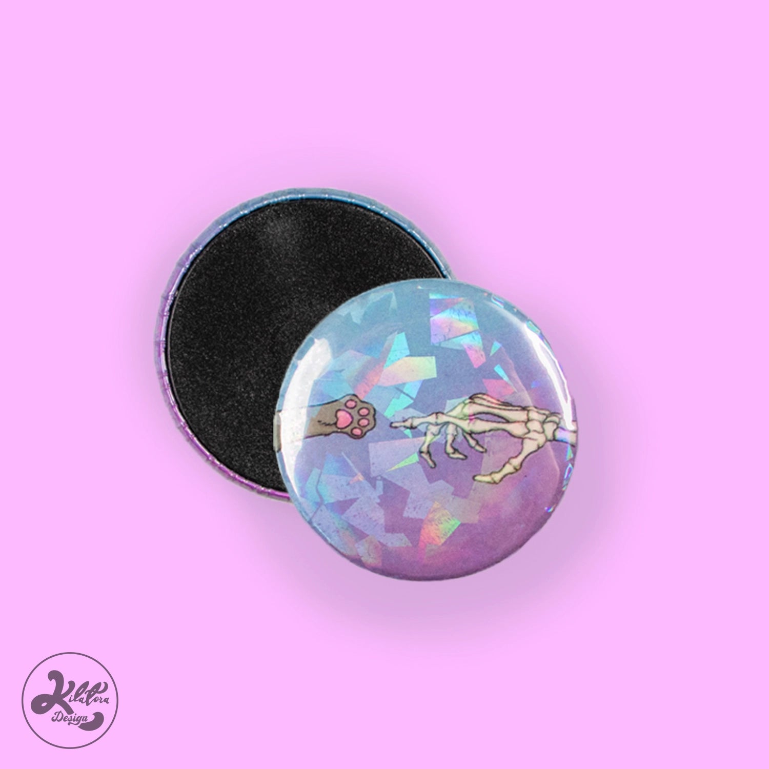 38mm magnet by Kilatora Design. Blue and purple color with broken glass holographic effect. A gray cat's paw reaches for a skeleton's hand.