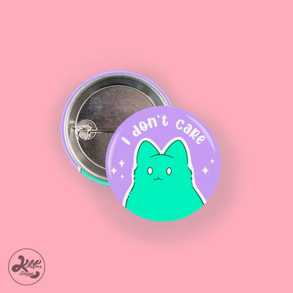 38mm button pin by Kilatora Design. Purple pin with a green kitty and text "I don't care".