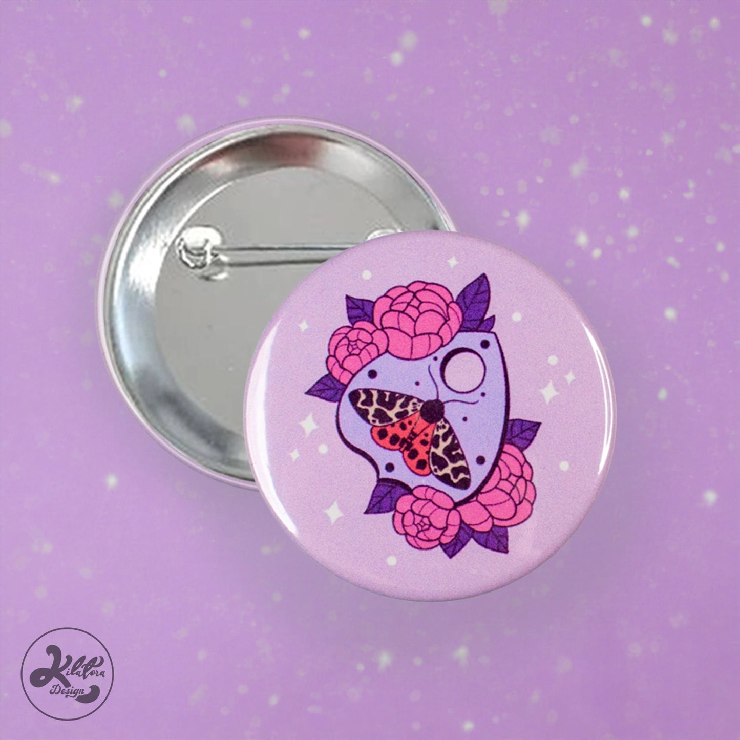 59mm button pin by Kilatora Design. Light purple color with purple ouija, a moth with white and orange wings and lilac flowers.